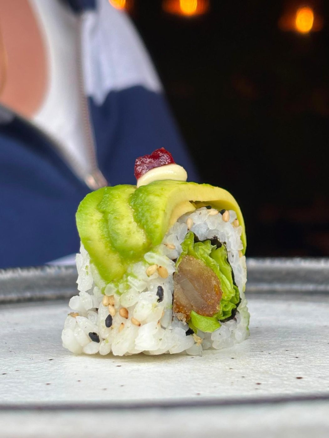 Roll avocat et poisson en gros plan, riz à l'extérieur, chez Sushi Rainbow