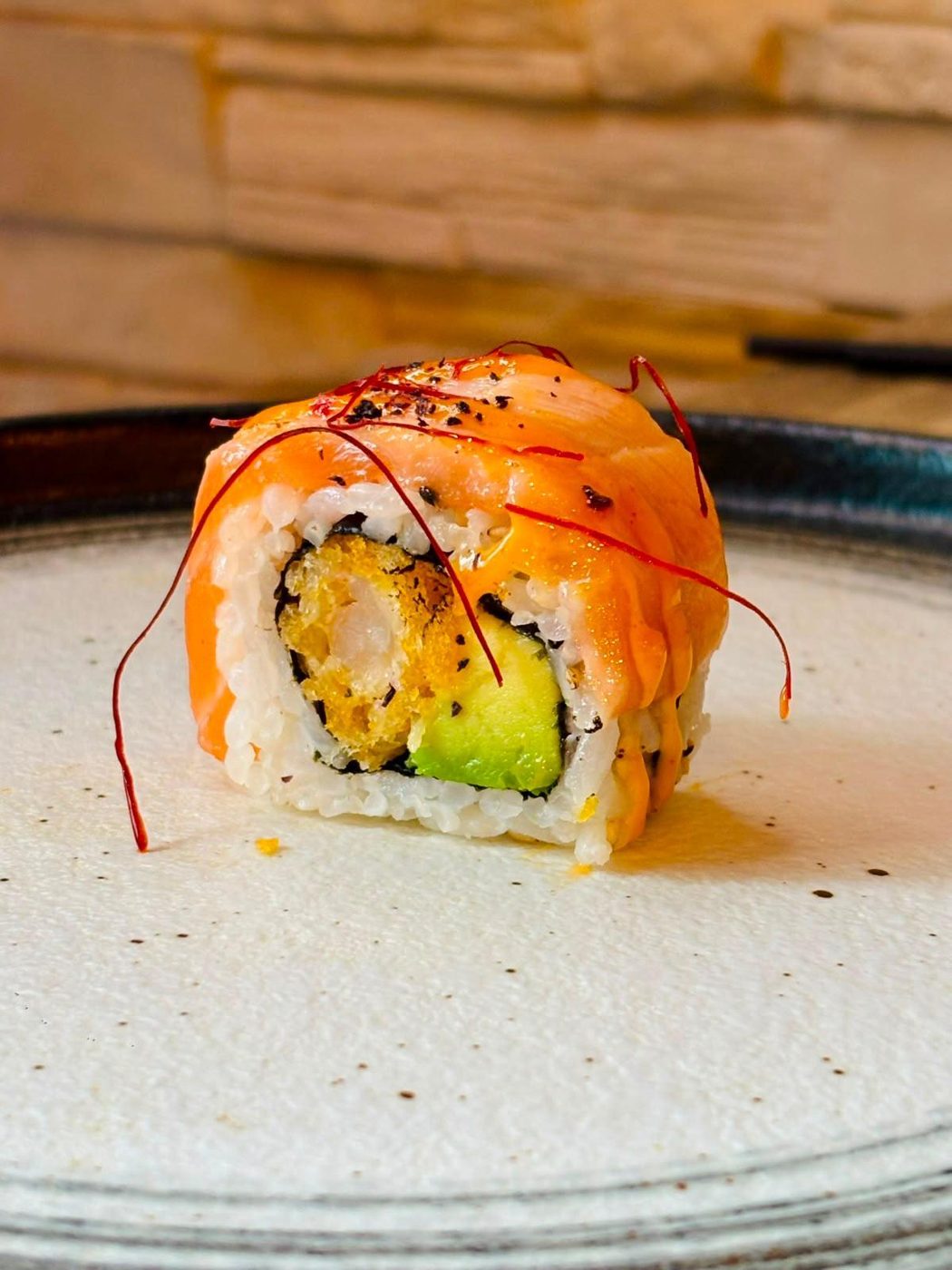 Roll saumon braisé coupé en gros plan montrant le riz vinaigré et la garniture