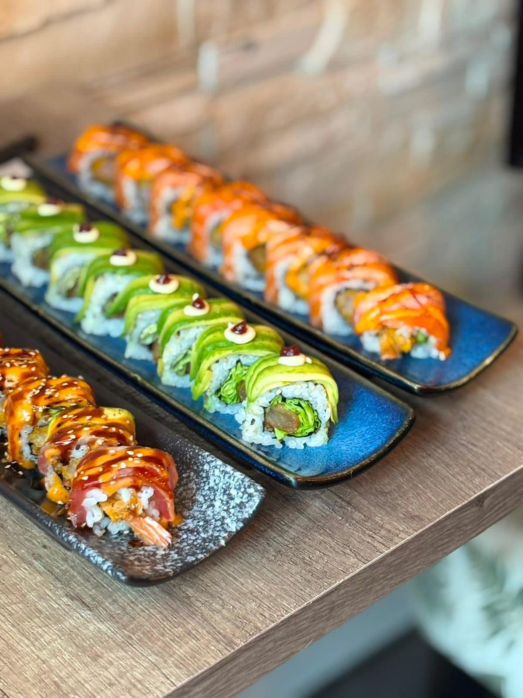 Assortiment de makis japonais colorés dressés sur ardoise, Sushi Rainbow Paris
